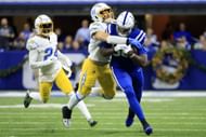 Jelani Woods #80 of the Indianapolis Colts tackled by Drue Tranquill #49 of the Los Angeles Chargers